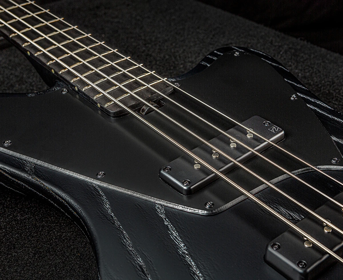 Bass strings running across the pickups and pickguard toward the neck.