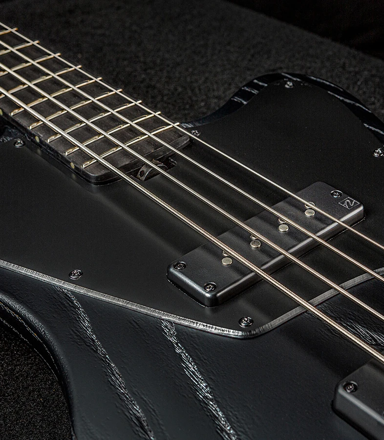 Bass strings running across the pickups and pickguard toward the neck.
