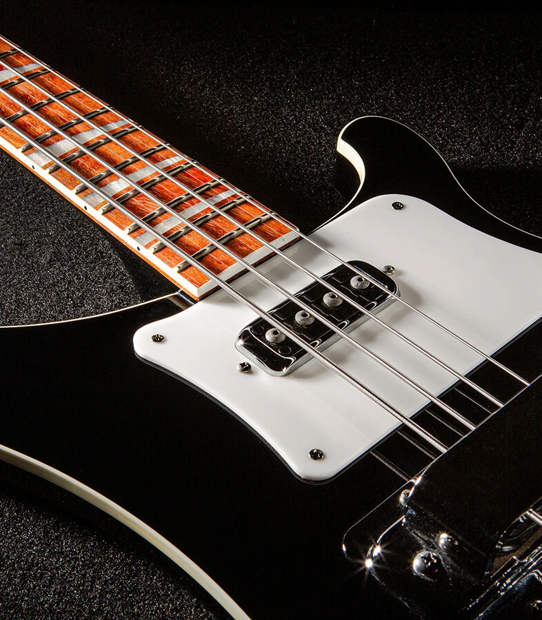 Bass strings running across the pickups and pickguard and over the neck.