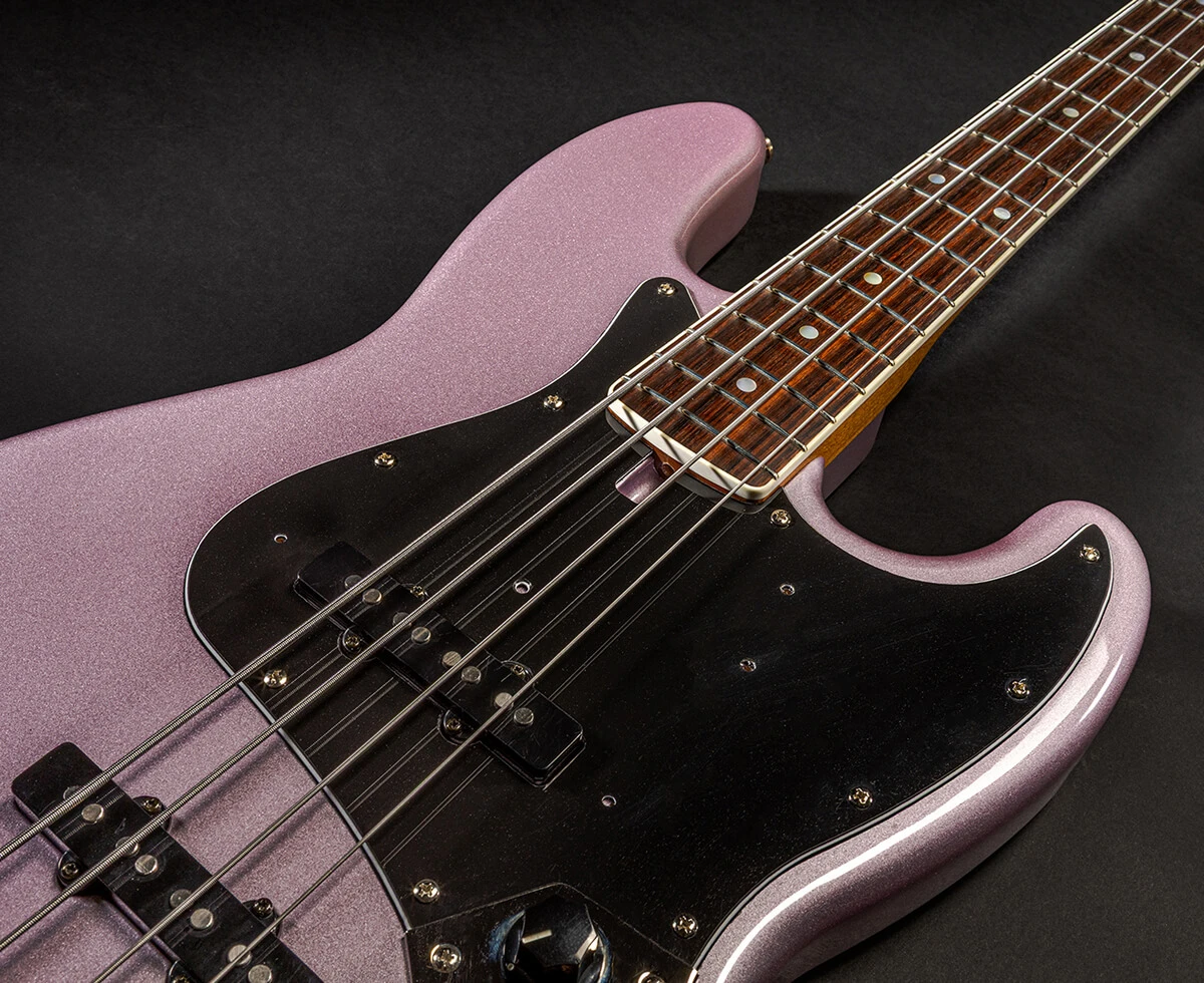 The strings of a four-string bass running the length of the fretboard toward the headstock.