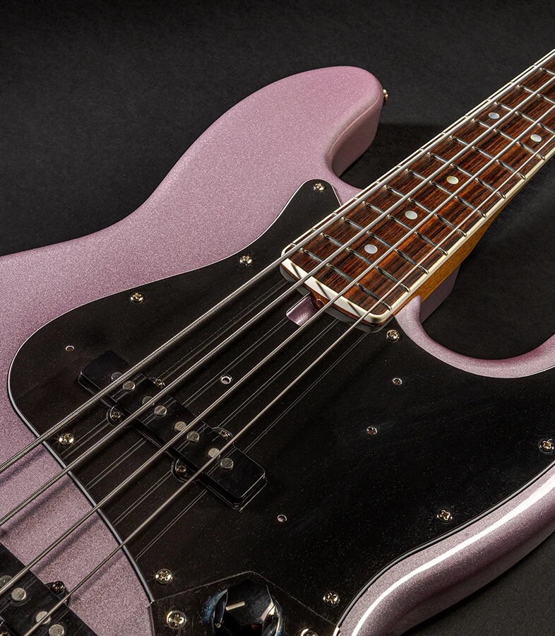 The strings of a four-string bass running the length of the fretboard toward the headstock.