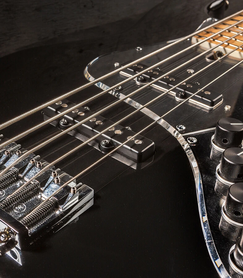 Bass strings running across the pickups and pickguard toward the neck.