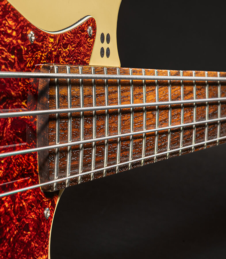 The strings of a four-string bass running the length of the fretboard toward the headstock.