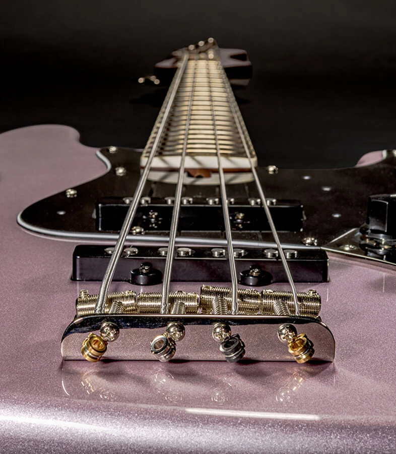 The strings of a four-string bass anchored at the bridge saddles.
