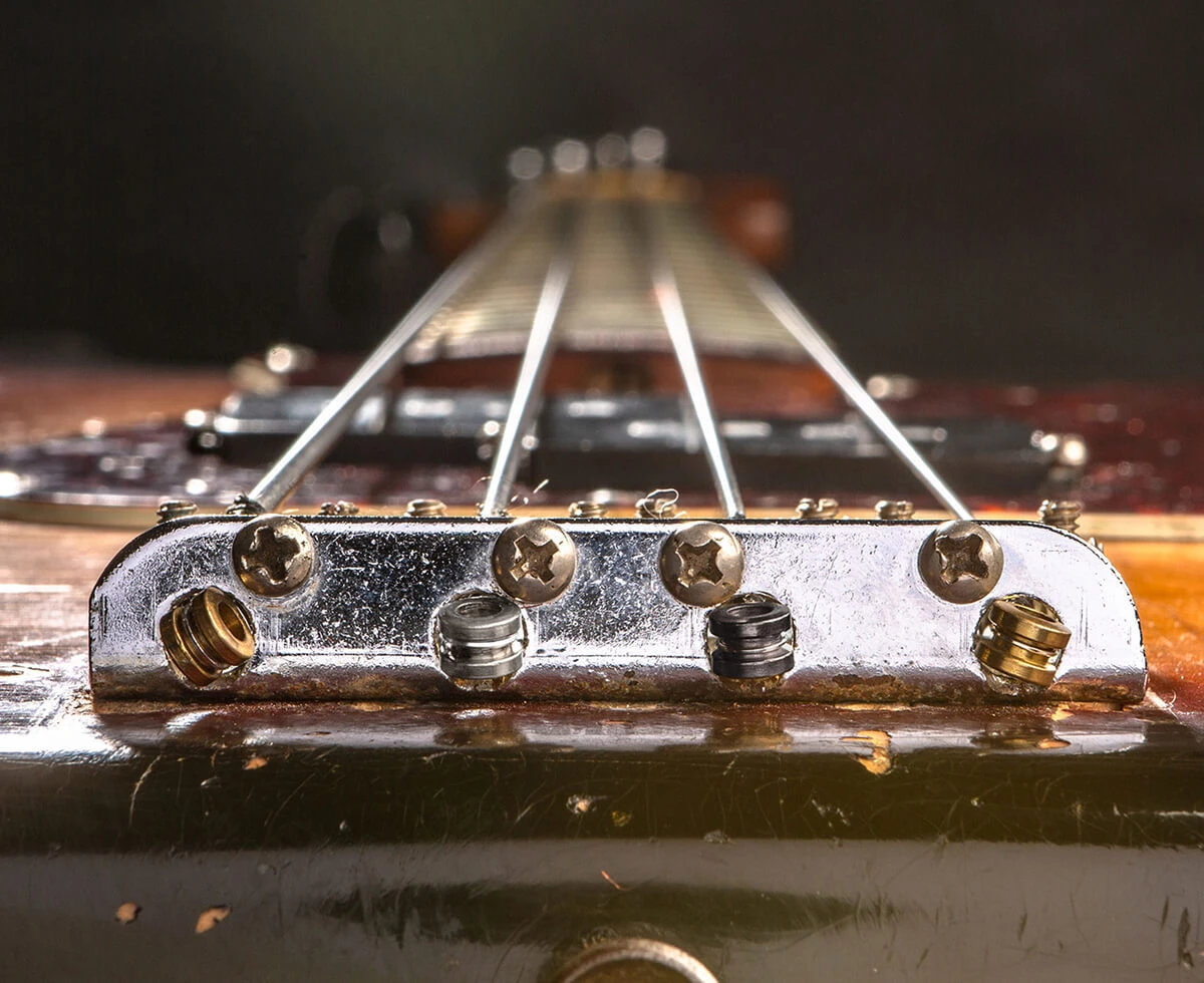 The strings of a four-string bass anchored at the bridge saddles.
