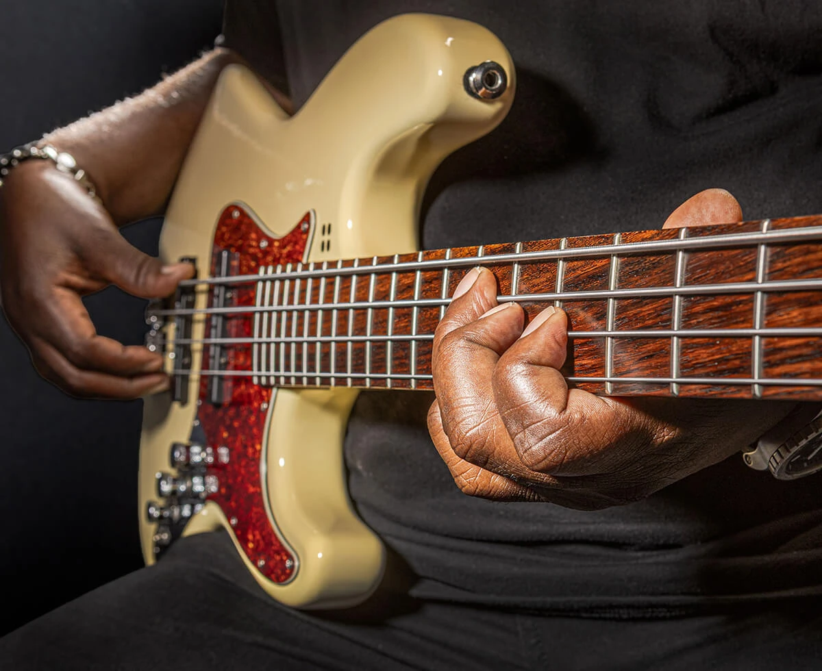 A player fretting the strings of a four-string bass.