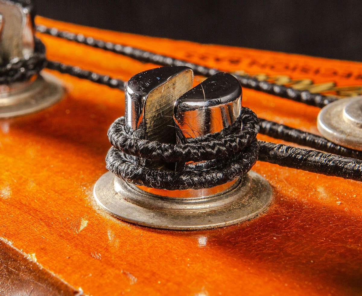A bass string wound around a tuning post on the headstock.
