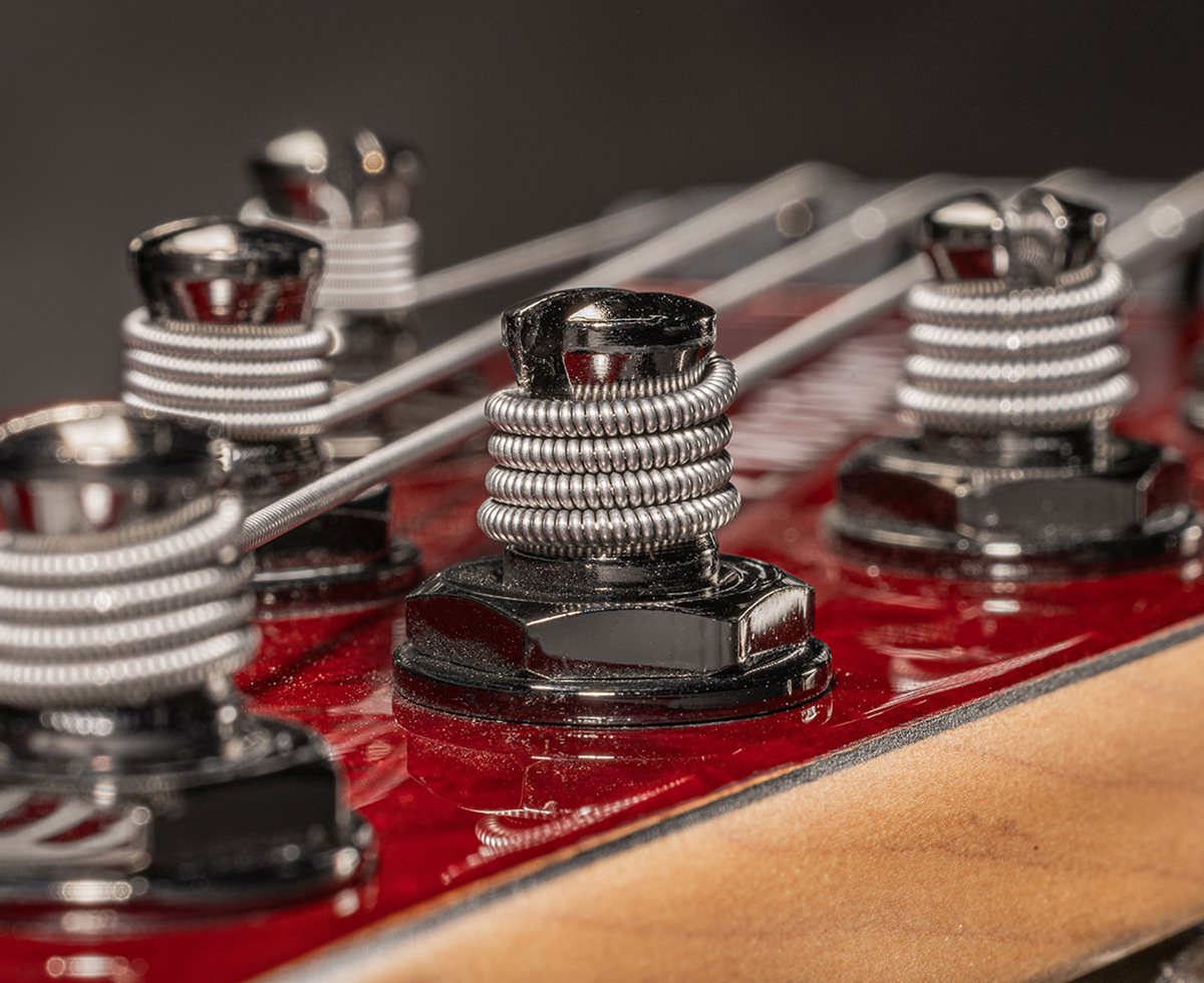  Strings wound around the tuning posts on a bass headstock.