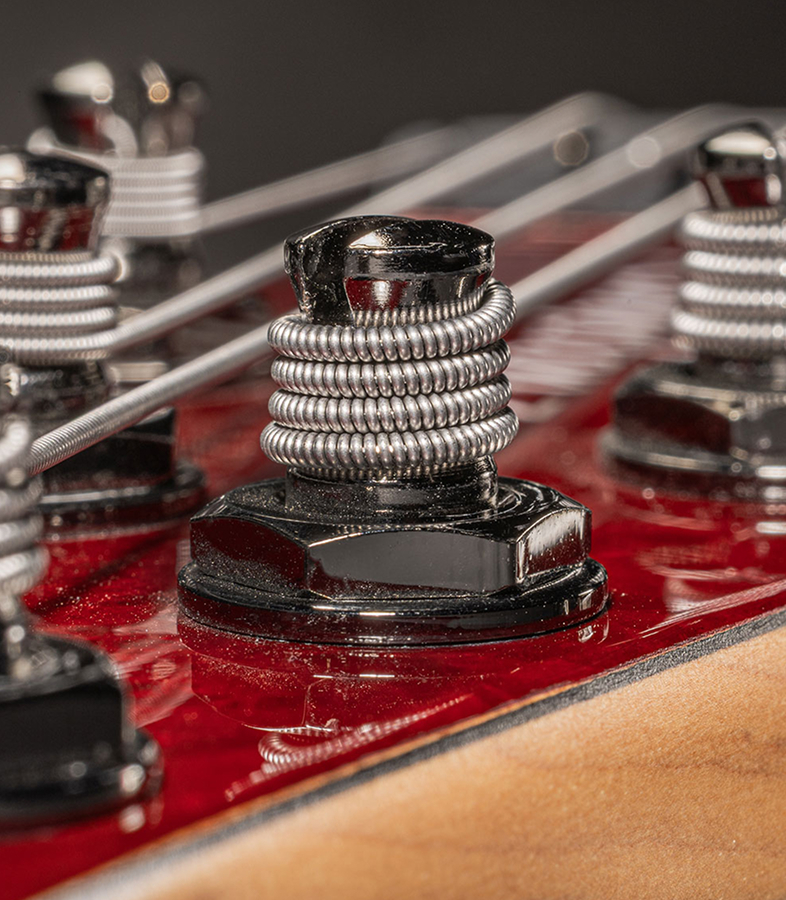  Strings wound around the tuning posts on a bass headstock.