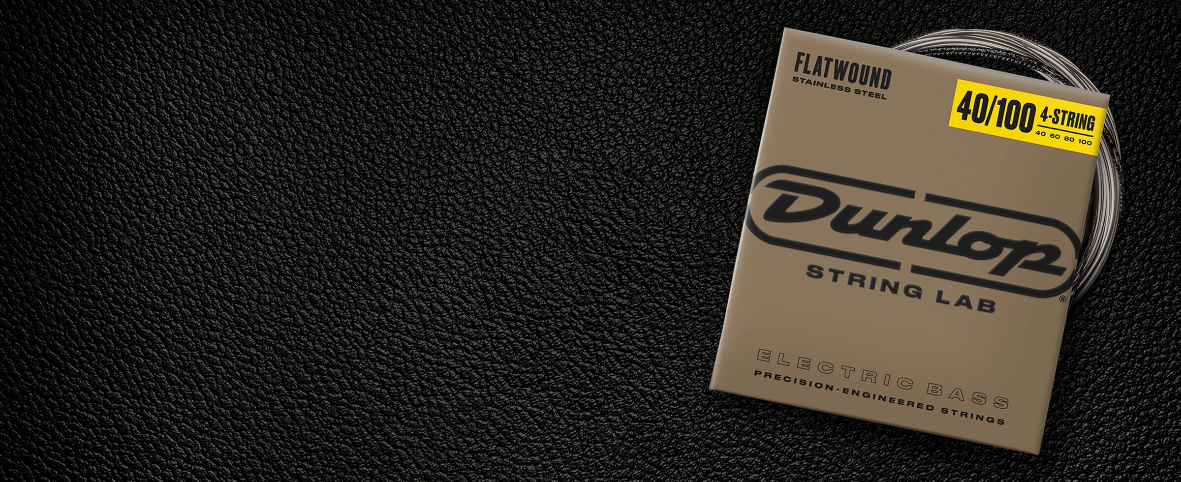 A Dunlop bass string package with the coiled strings fanned out beside it.
