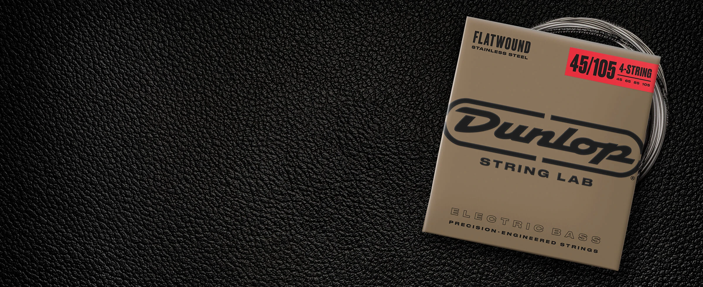 A Dunlop bass string package with the coiled strings fanned out beside it.
