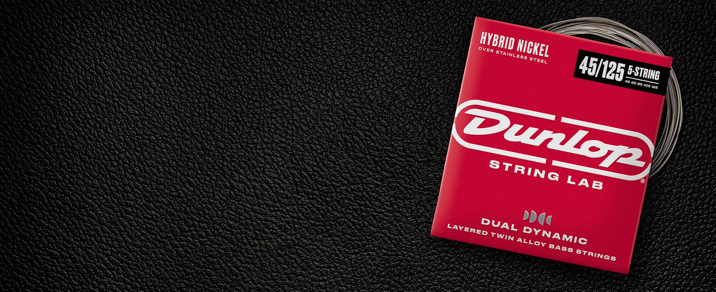 A Dunlop bass string package with the coiled strings fanned out beside it.