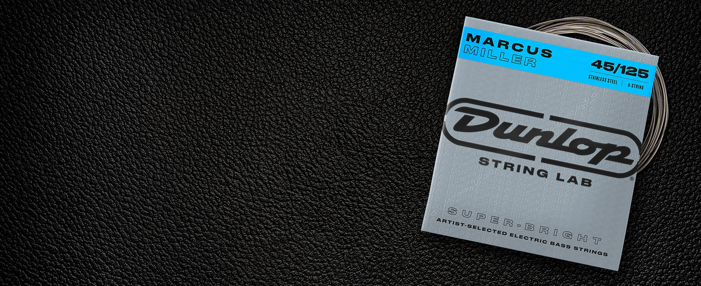 A Dunlop bass string package with the coiled strings fanned out beside it.