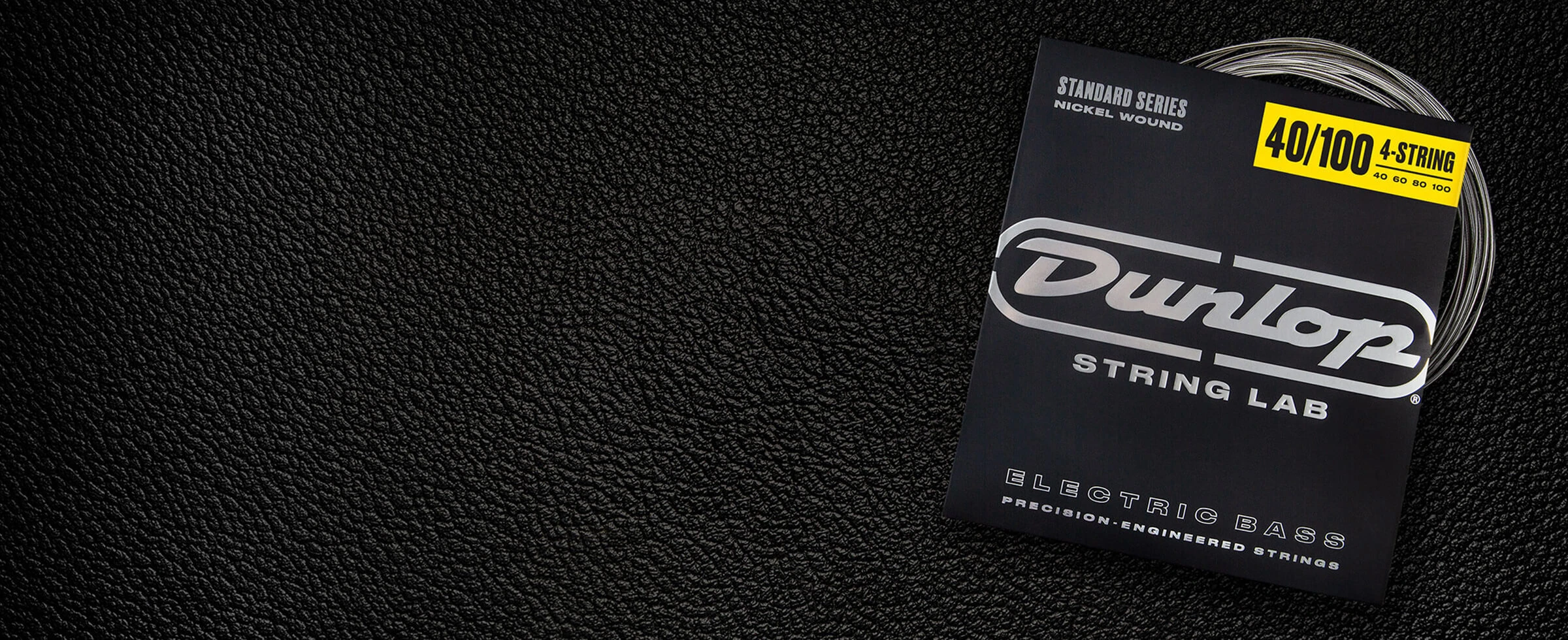 A Dunlop bass string package with the coiled strings fanned out beside it.