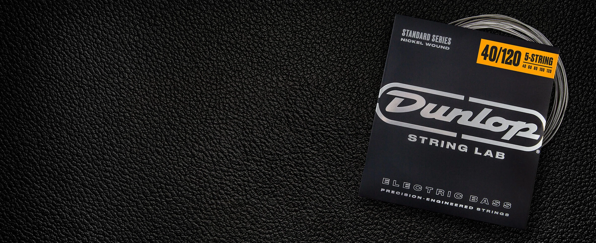 A Dunlop bass string package with the coiled strings fanned out beside it.