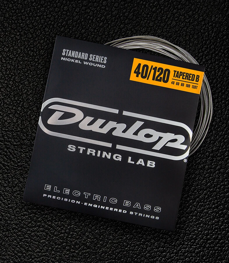 A Dunlop bass string package with the coiled strings fanned out beside it.