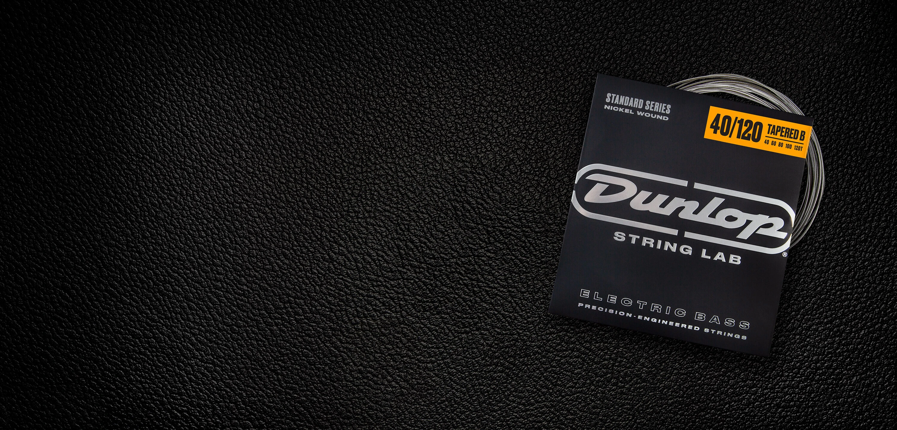 A Dunlop bass string package with the coiled strings fanned out beside it.