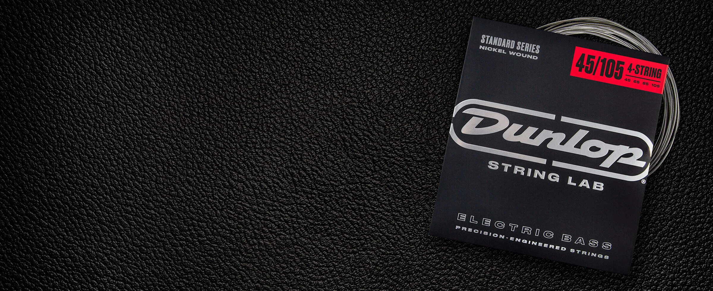 A Dunlop bass string package with the coiled strings fanned out beside it.