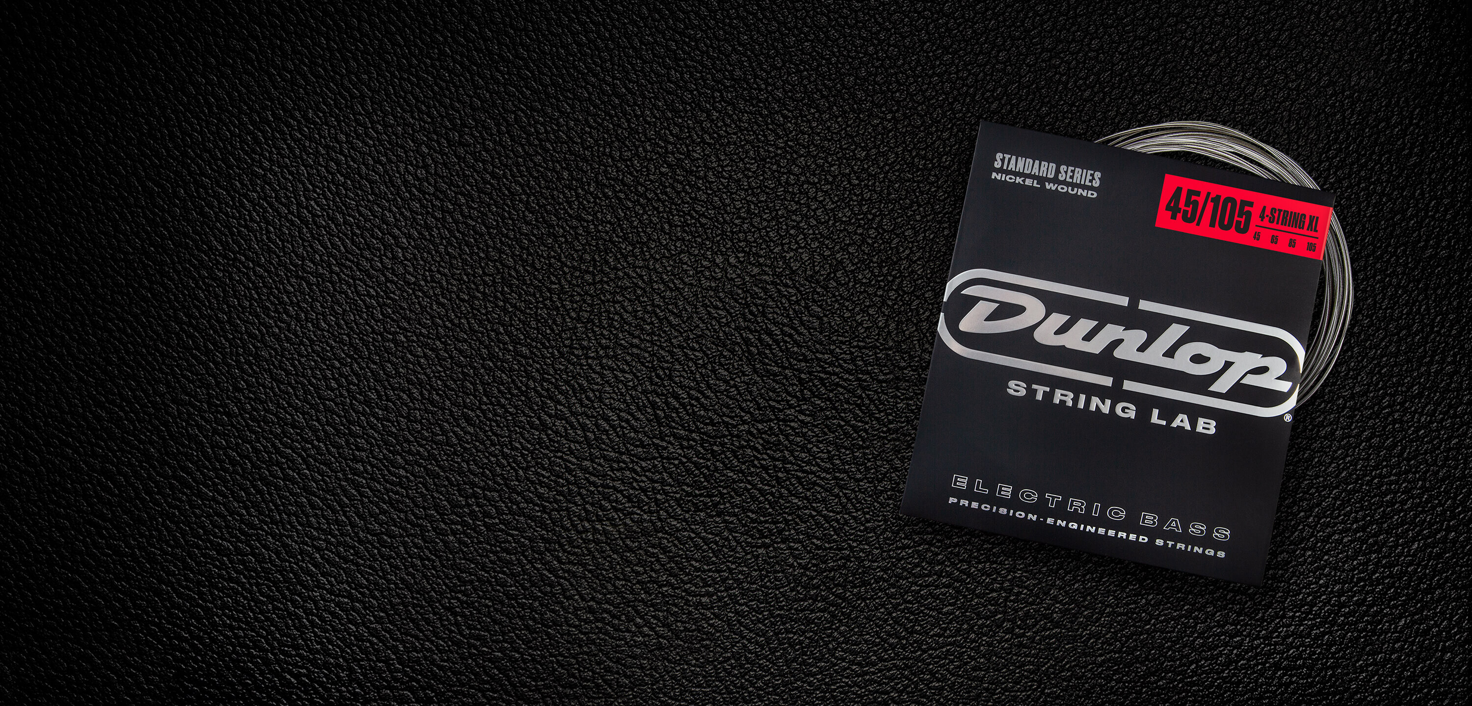 A Dunlop bass string package with the coiled strings fanned out beside it.