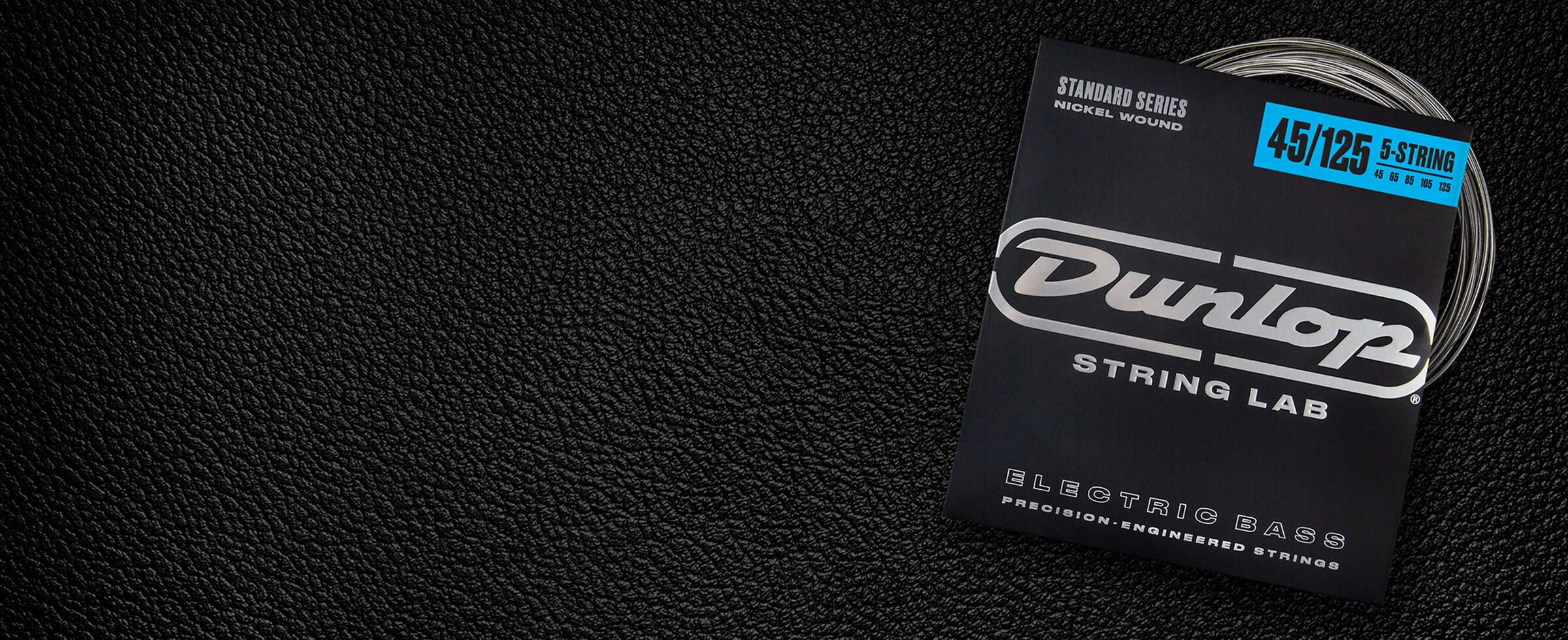 A Dunlop bass string package with the coiled strings fanned out beside it.