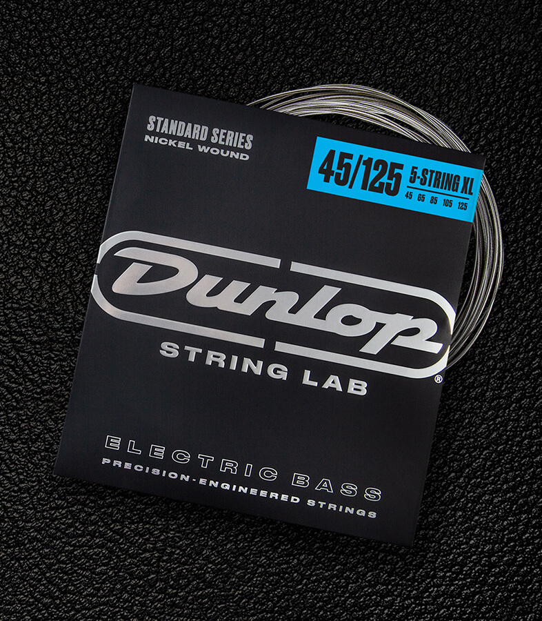 A Dunlop bass string package with the coiled strings fanned out beside it.