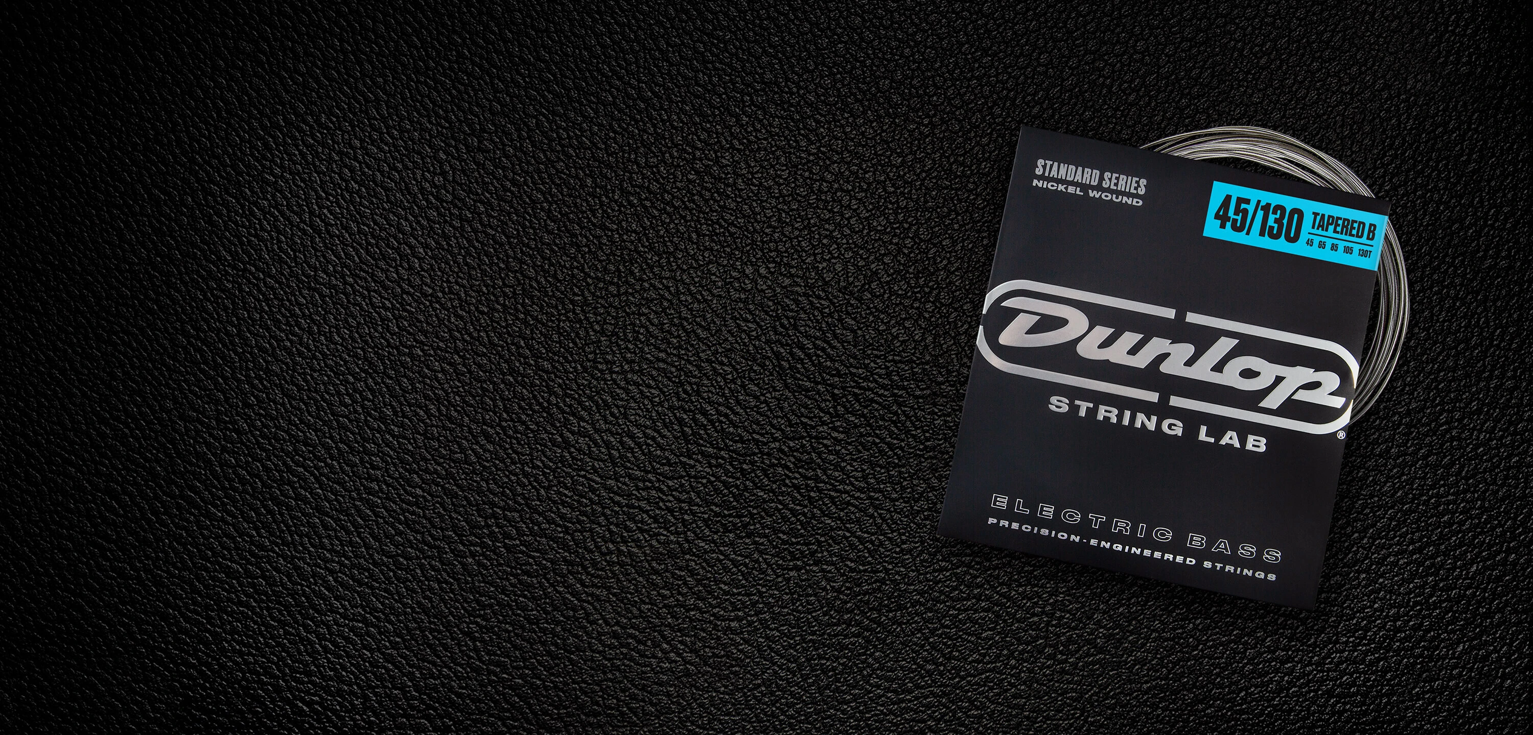 A Dunlop bass string package with the coiled strings fanned out beside it.