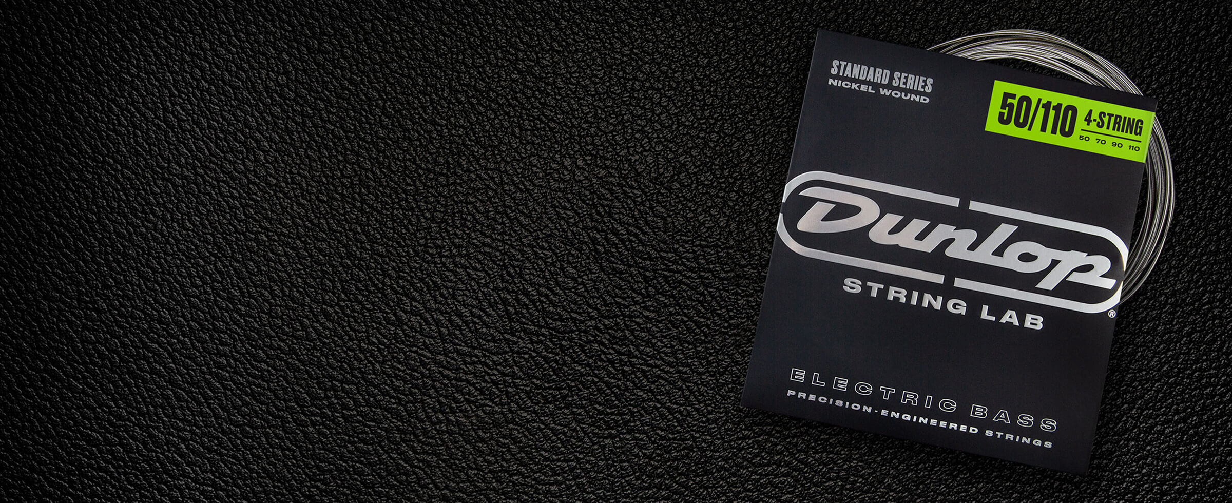 A Dunlop bass string package with the coiled strings fanned out beside it.