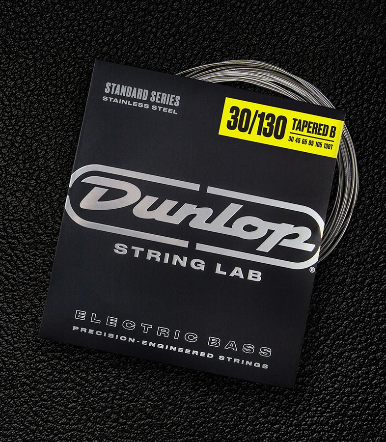 A Dunlop bass string package with the coiled strings fanned out beside it.