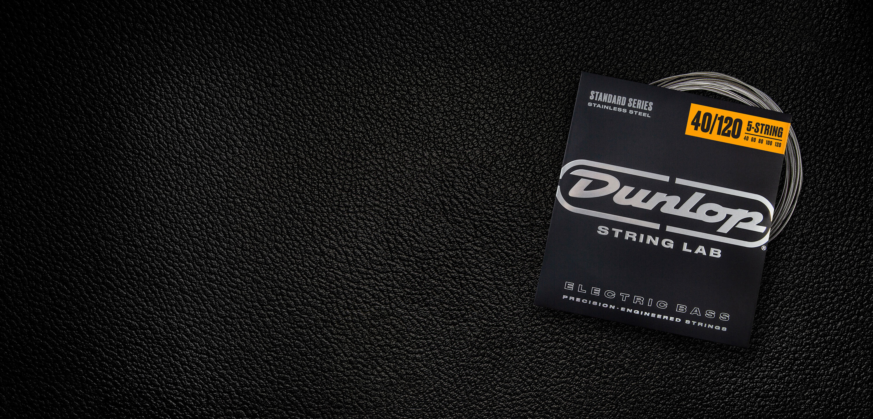A Dunlop bass string package with the coiled strings fanned out beside it.