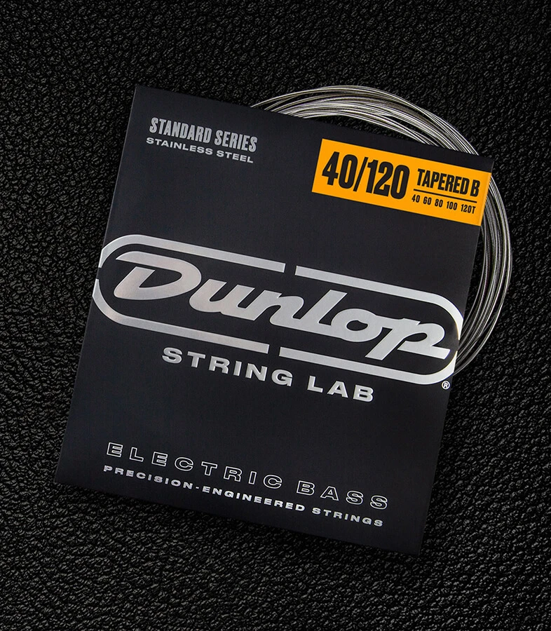 A Dunlop bass string package with the coiled strings fanned out beside it.