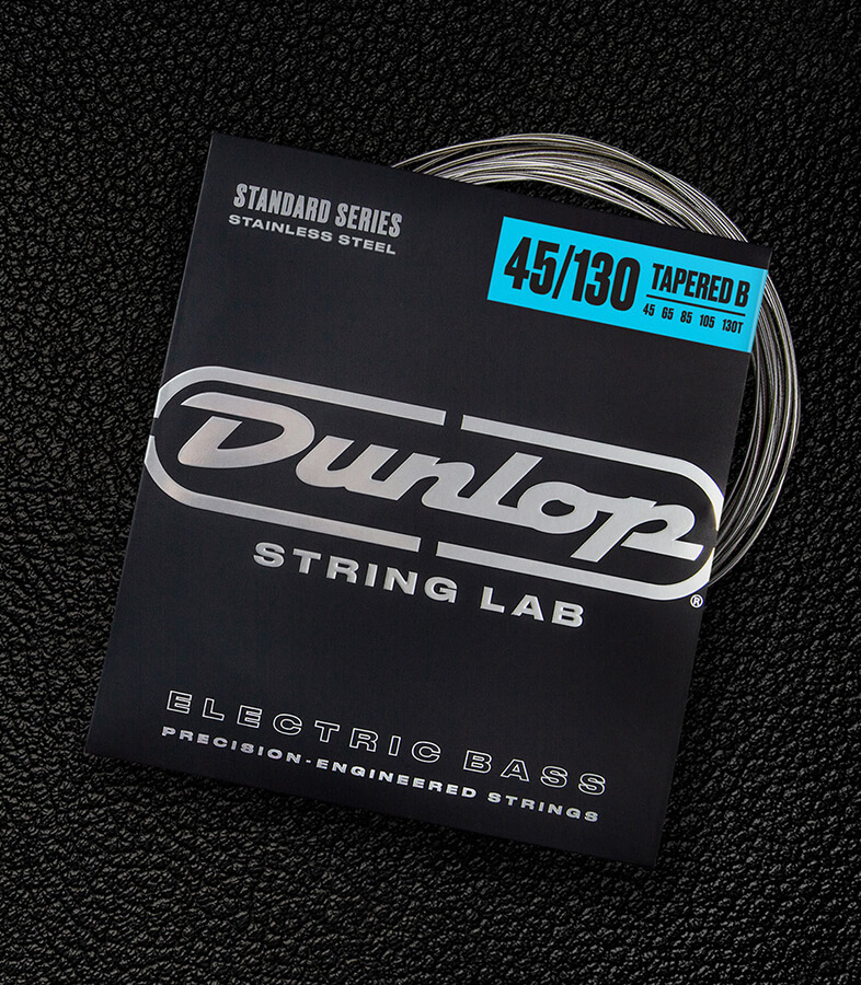 A Dunlop bass string package with the coiled strings fanned out beside it.