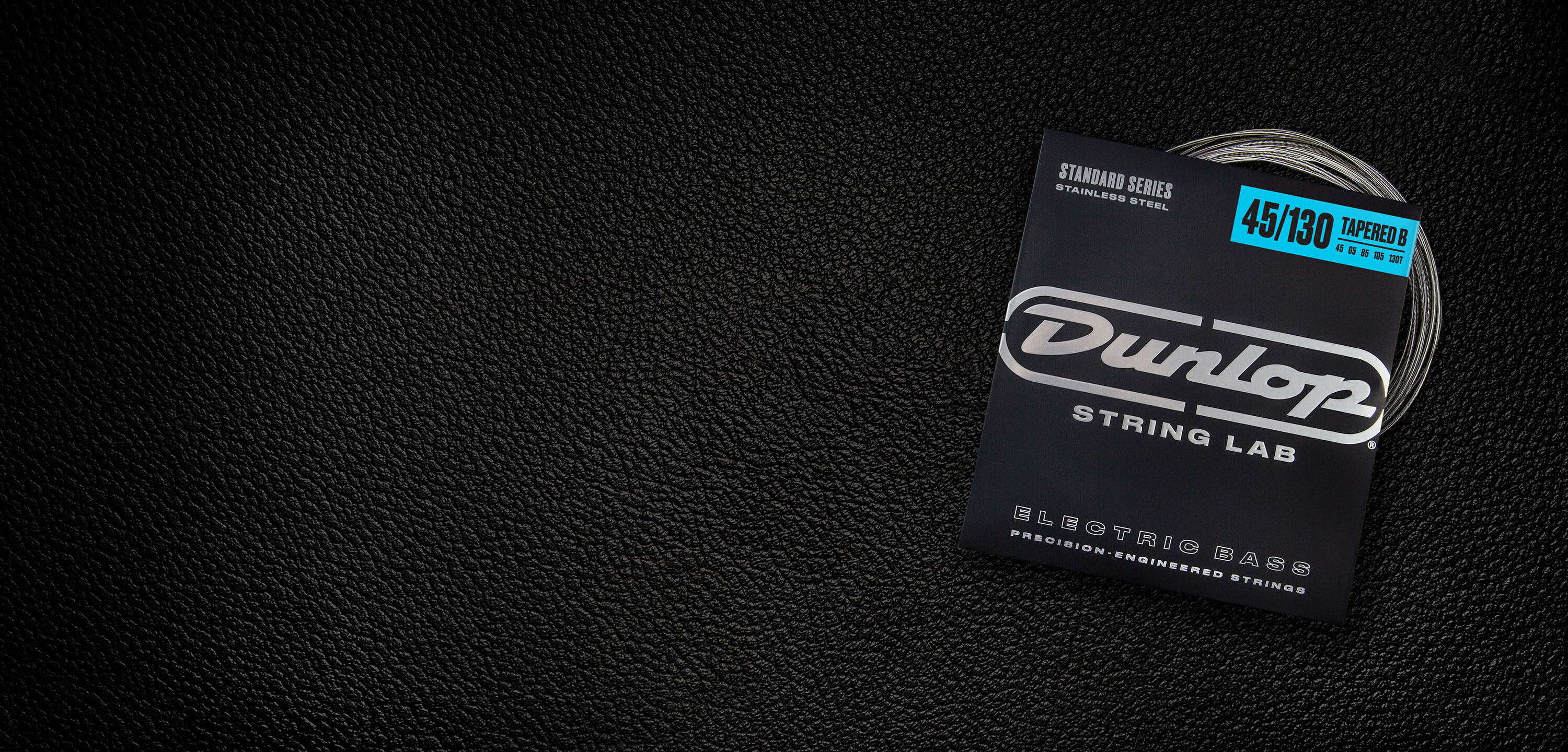 A Dunlop bass string package with the coiled strings fanned out beside it.