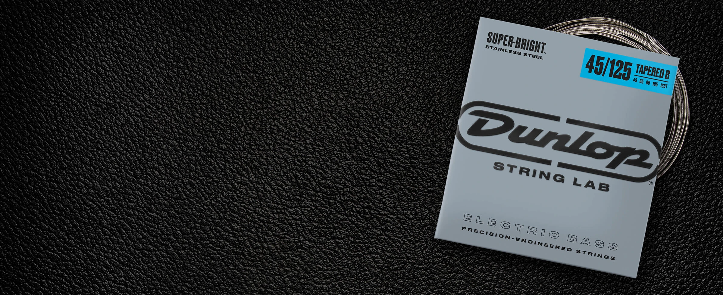 A Dunlop bass string package with the coiled strings fanned out beside it.