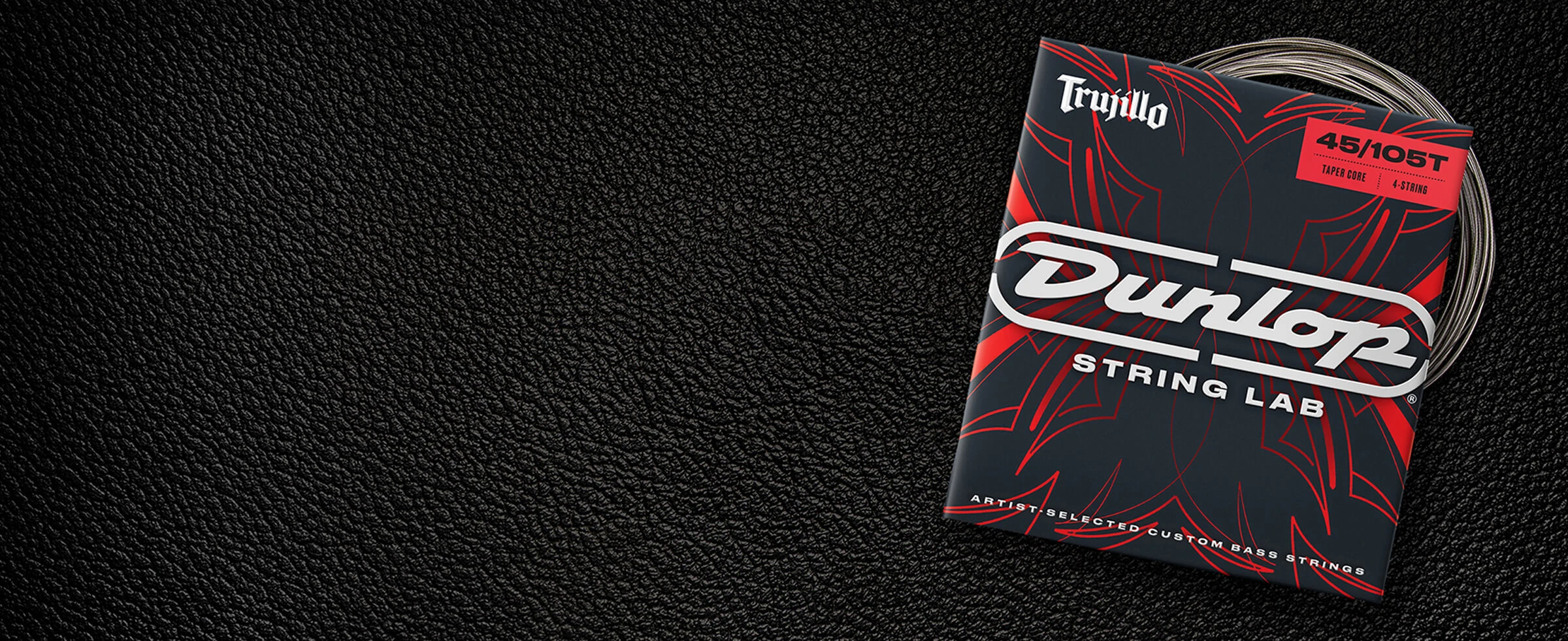 A Dunlop bass string package with the coiled strings fanned out beside it.