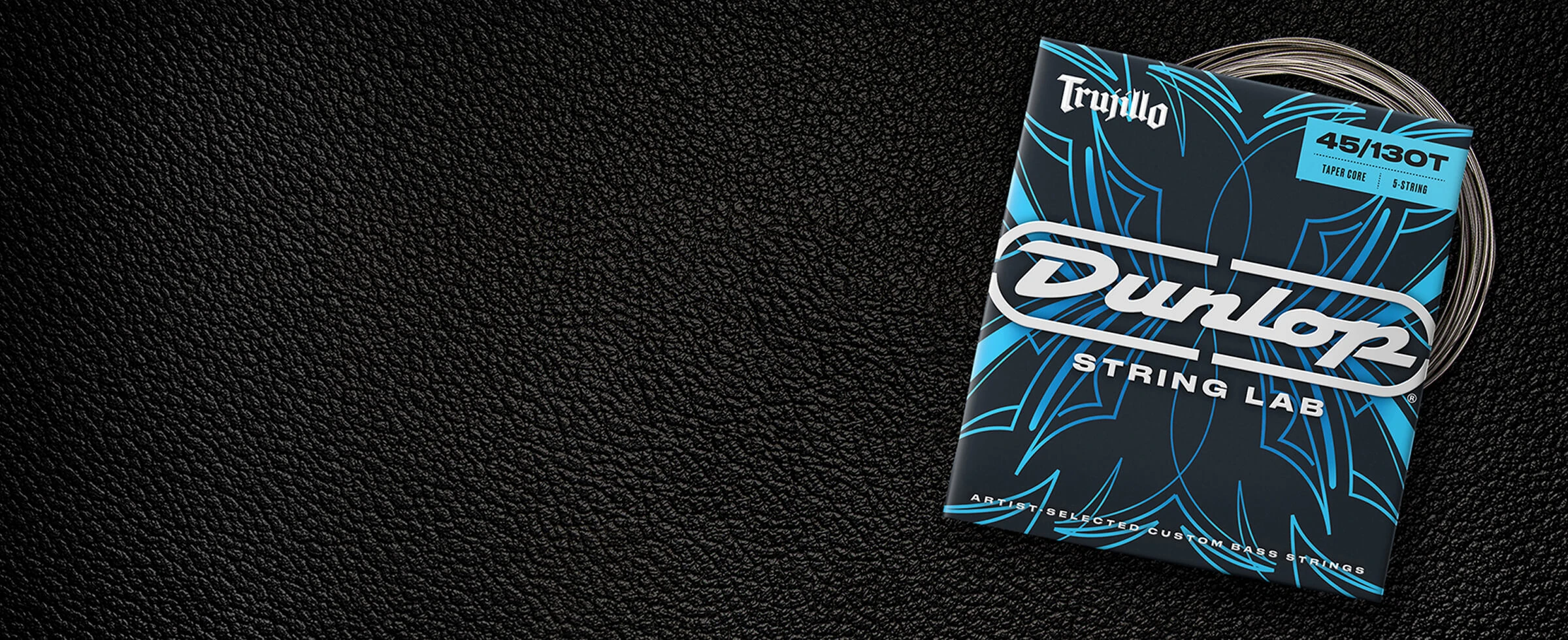 A Dunlop bass string package with the coiled strings fanned out beside it.