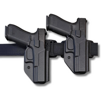 Two black Low Rider OWB holsters with pistols inserted, mounted side-by-side on a black tactical belt. Showing the 2 differnt ride heights.