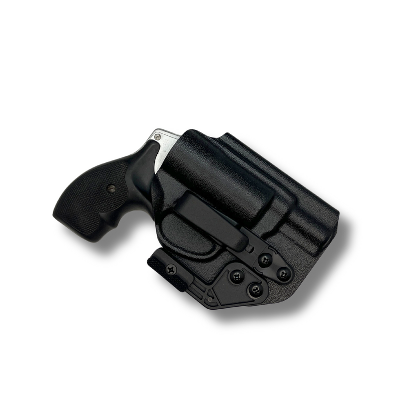 Black Kydex revolver holster with concealment wing and overhook clip holding a J-Frame revolver.