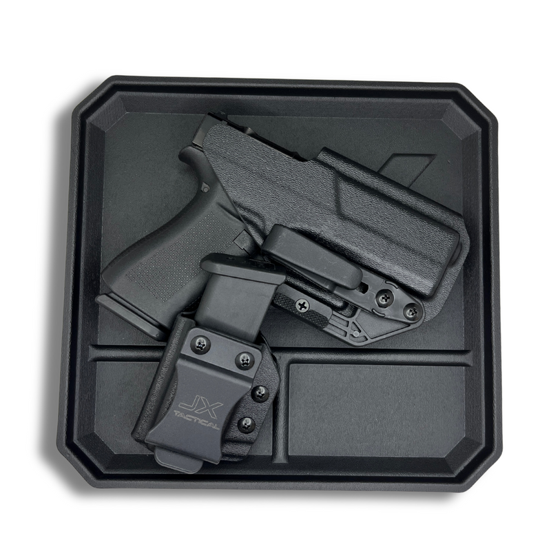 Black Skinny Guy holster with a Glock pistol and matching JX Tactical mag pouch displayed on a black EDC tray.