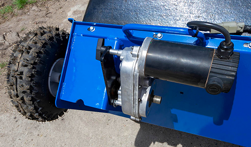 The two 12-VDC motors are powered by your tractor. An 8-foot Fused Power Cable directly connects to your tractor’s battery. The outside motor is geared to run at a faster RPM than the inside motor. The keyed axle shafts are mounted through the hopper’s existing wheel holes using bushings, brackets, and lock collars. The wheels follow the factory hopper arc. The motors can be easily removed by loosening the anti-rotation bracket knob and sliding the motor off the axle shaft.