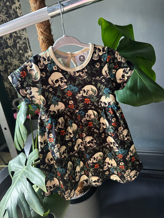 Alternative baby dress with a garden skull print, gothic floral style.