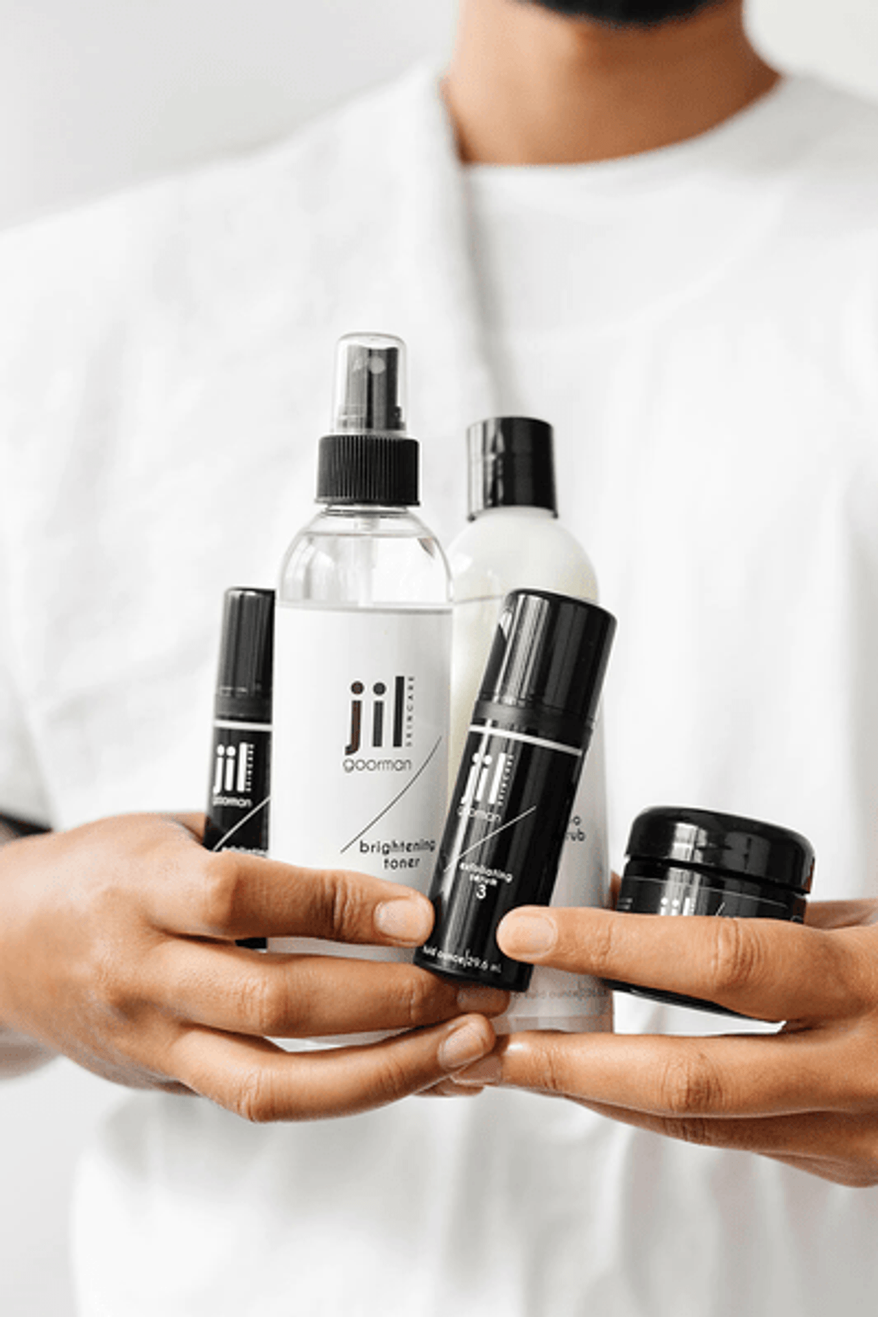 close up of man's arms holding an array of five different products 