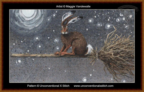 A cross-stitch pattern that depicts a whimsical scene of a brown hare perched on a broomstick against a starry night sky. The hare, with distinctively large ears and bright eyes, is seated towards the right side of the wooden broomstick, which stretches horizontally across the image. The background is a textured, dark sky sprinkled with white specks resembling stars or snowflakes. In the upper left corner, a stylized glowing moon is visible, surrounded by soft halos of light. The broomstick has twigs fanned out at one end, adding to its rustic appearance.