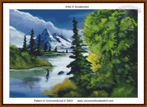cross stitch pattern of a landscape with snow capped mountain evergreen trees and a calm body of water with a mysterious loch monster