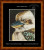 A cross-stitch pattern of a kookaburra, focusing on its head. The bird's feathers are rendered in intricate detail with shades of brown, white, and blue, creating a textured and realistic appearance. Its eye is round and expressive, with a black pupil outlined in white. The beak is prominent, colored in a gradient from dark blue to light brown at the tip. The background is a deep black, which contrasts with the bird's light-coloured feathers. 