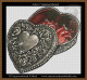 cross stitch pattern of a heart shaped metal box with floral engravings open to reveal a realistic human heart inside