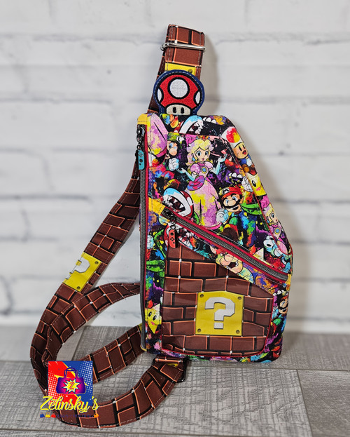 Sling style backpack designed to carry portable video gaming systems and cartridges on the go