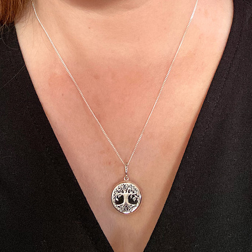 Hand crafted round sterling silver tree of life necklace with organic black stone