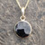 Circular 9ct gold and Whitby Jet pendant on gold curb chain