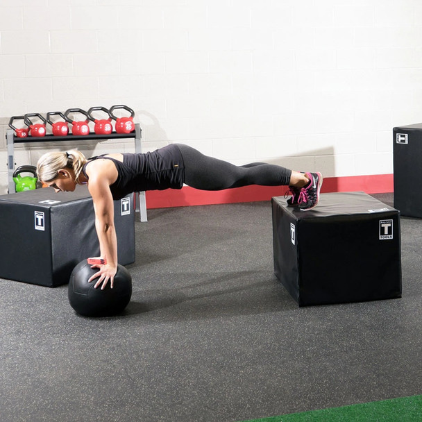 Woman Training Elevated Foot Push-Ups on Body-Solid Plyo Box in Gym