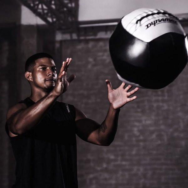 Dynamax 14" Standard Medicine Balls - Man Exercising in Commercial Gym